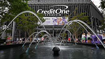 A fountain view of Credit One Stadium, with people walking inside. 