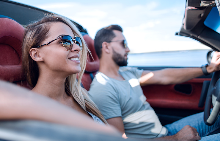 A Couple Driving In a Convertible Car